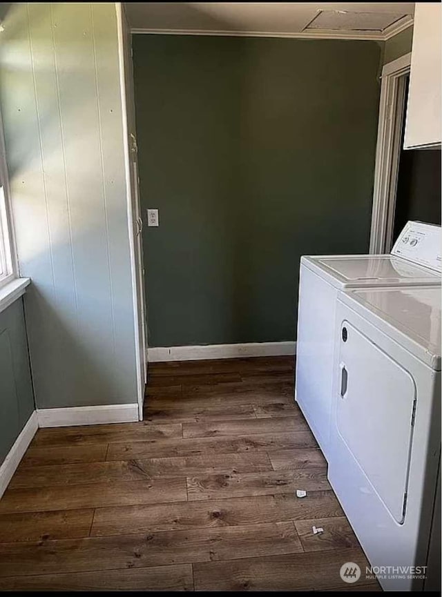 laundry room with crown molding, dark hardwood / wood-style floors, and washing machine and dryer