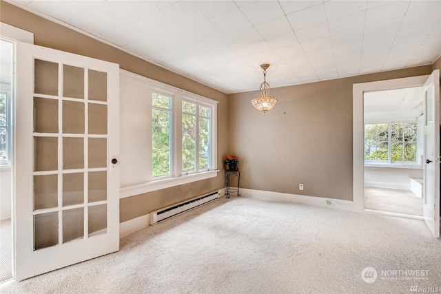 carpeted empty room featuring a notable chandelier and a baseboard heating unit