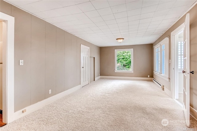 empty room with carpet and baseboard heating