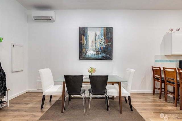 dining area featuring a wall mounted AC and light hardwood / wood-style floors