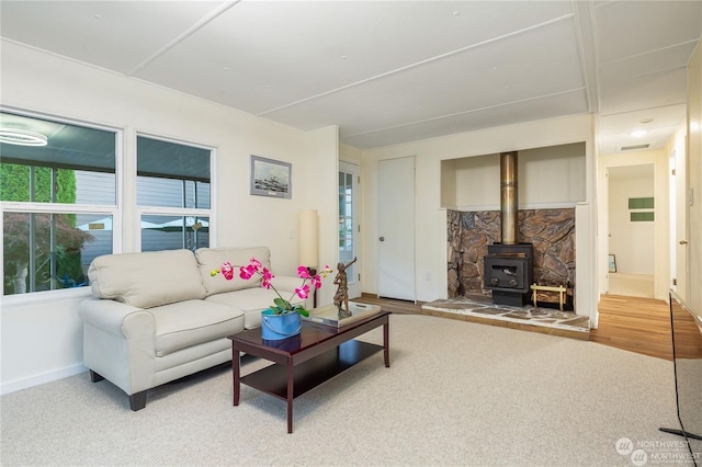 carpeted living room featuring a wood stove