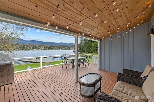 deck with grilling area and a water and mountain view