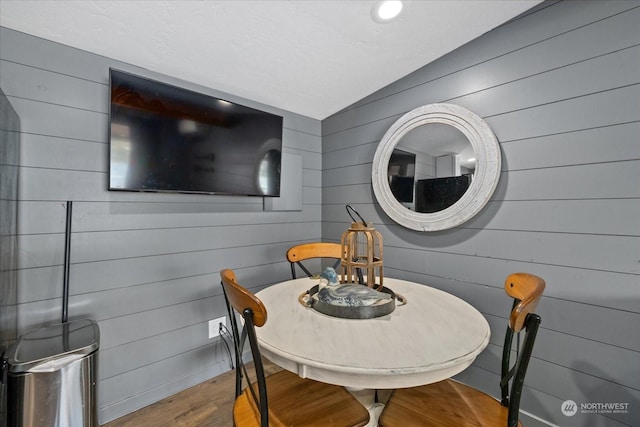 dining room featuring wood walls and hardwood / wood-style flooring