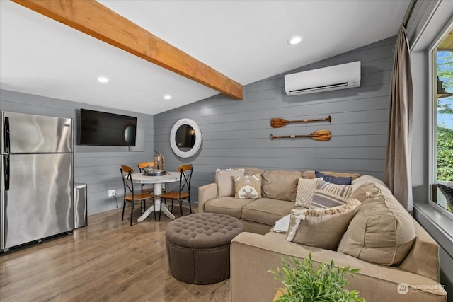 living room with plenty of natural light, an AC wall unit, wood-type flooring, and vaulted ceiling with beams