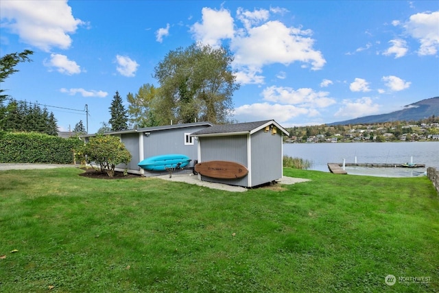 view of outbuilding featuring a lawn and a water and mountain view