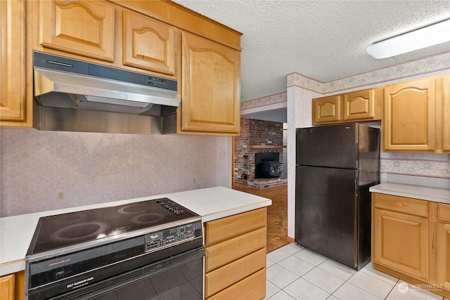 kitchen featuring black appliances, light tile patterned flooring, and a textured ceiling