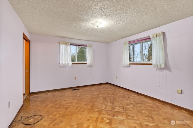 unfurnished bedroom featuring a textured ceiling and light parquet floors