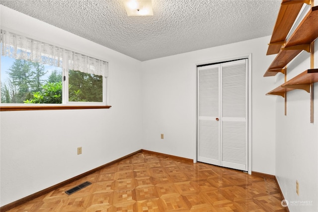 unfurnished bedroom featuring a textured ceiling and a closet