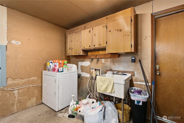 clothes washing area with electric panel, sink, cabinets, and washer / dryer