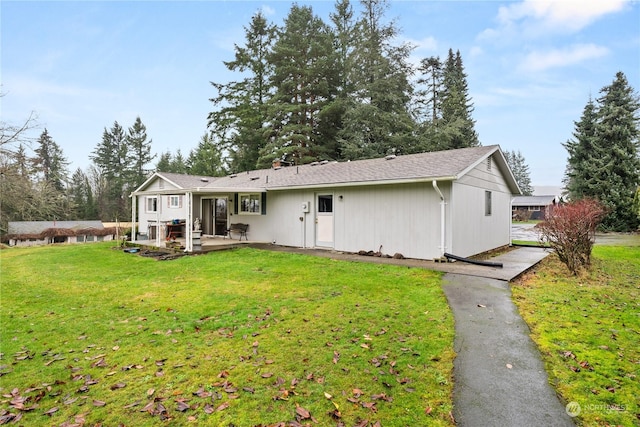 rear view of house with a lawn and a patio