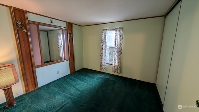 empty room with dark carpet and ornamental molding