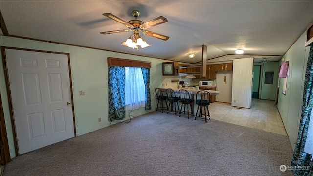 unfurnished living room featuring vaulted ceiling, ceiling fan, crown molding, and light carpet