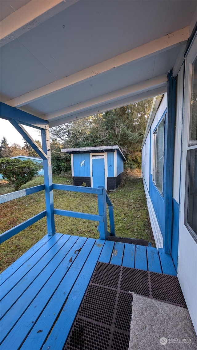 exterior space featuring a wooden deck and a shed