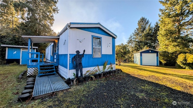 view of front of property featuring a garage, a front yard, and a storage unit