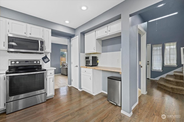 kitchen featuring white cabinets, stainless steel appliances, hardwood / wood-style flooring, and butcher block counters