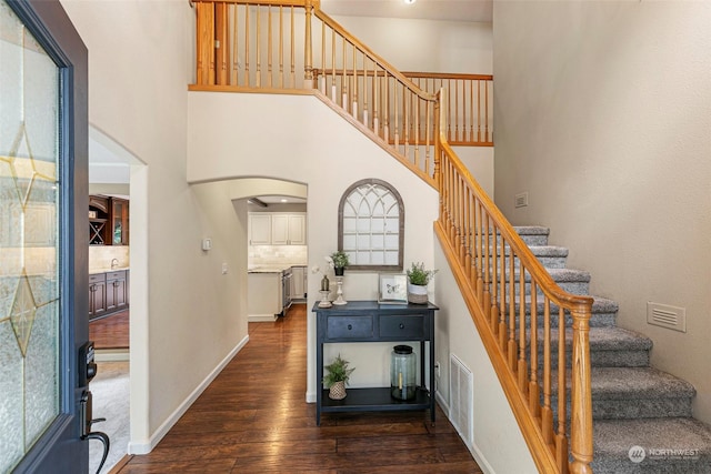 stairway with a high ceiling and hardwood / wood-style flooring