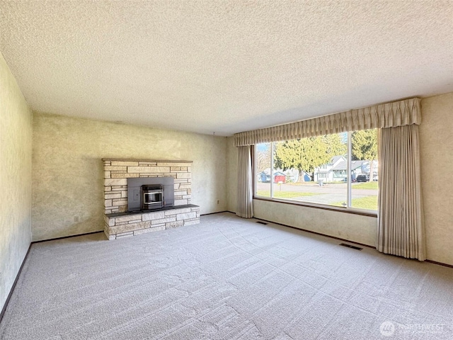 unfurnished living room featuring visible vents, carpet flooring, and a textured ceiling