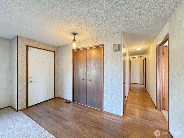 unfurnished bedroom with a closet, a textured ceiling, and wood finished floors