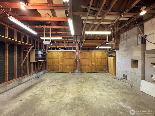 garage with concrete block wall and a garage door opener