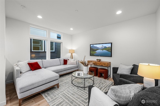 living room featuring baseboards, light wood finished floors, and recessed lighting