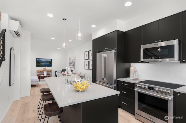 kitchen with light countertops, high end appliances, dark cabinets, and a wall mounted AC