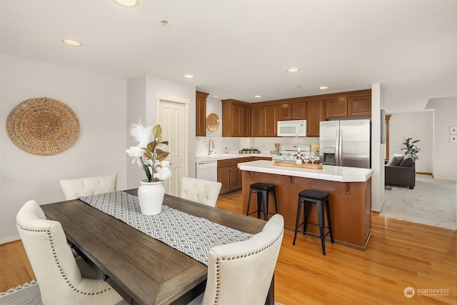 dining room with light hardwood / wood-style floors and sink