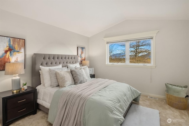 bedroom with light colored carpet and vaulted ceiling