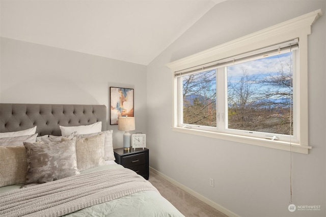 bedroom featuring light colored carpet and lofted ceiling