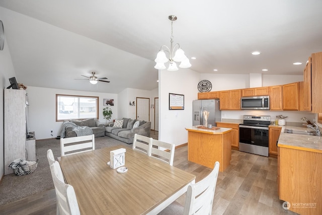 dining room with sink, light hardwood / wood-style floors, lofted ceiling, and ceiling fan with notable chandelier