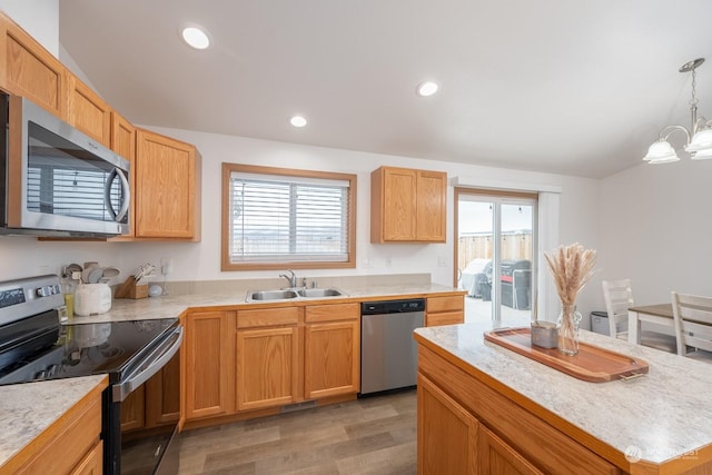 kitchen featuring stainless steel appliances, sink, an inviting chandelier, hardwood / wood-style floors, and pendant lighting