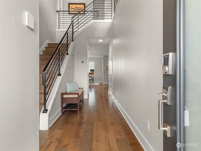 entrance foyer featuring a towering ceiling and hardwood / wood-style flooring