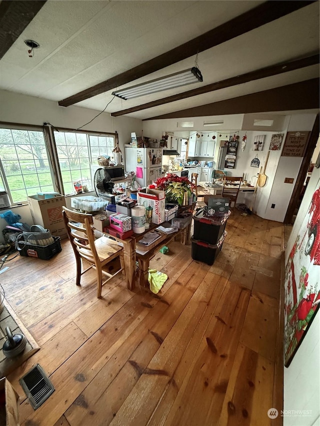 dining room with beamed ceiling and hardwood / wood-style flooring