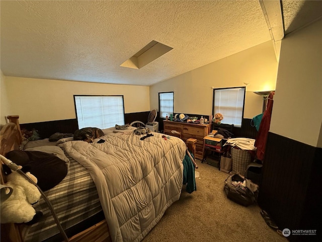 bedroom with carpet, a textured ceiling, and vaulted ceiling