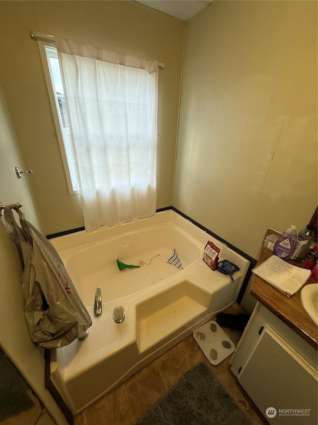 bathroom featuring tile patterned floors, vanity, and a bath