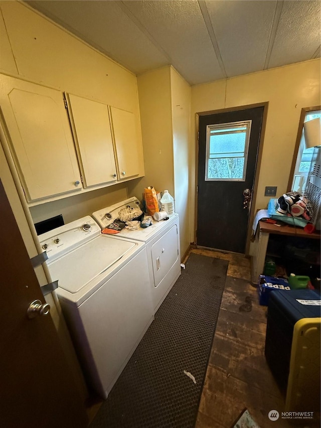 laundry room featuring separate washer and dryer, cabinets, and a textured ceiling