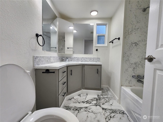 bathroom with vanity, tasteful backsplash, a tub, toilet, and marble finish floor