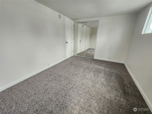 unfurnished bedroom featuring a closet, baseboards, and carpet