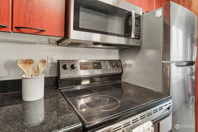 interior details with appliances with stainless steel finishes and dark stone counters