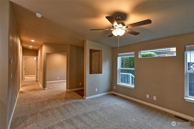 carpeted spare room featuring ceiling fan and lofted ceiling