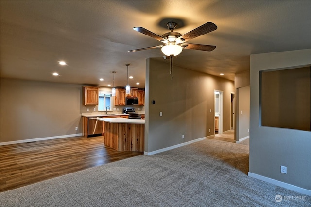 kitchen featuring sink, ceiling fan, decorative light fixtures, light colored carpet, and stainless steel appliances