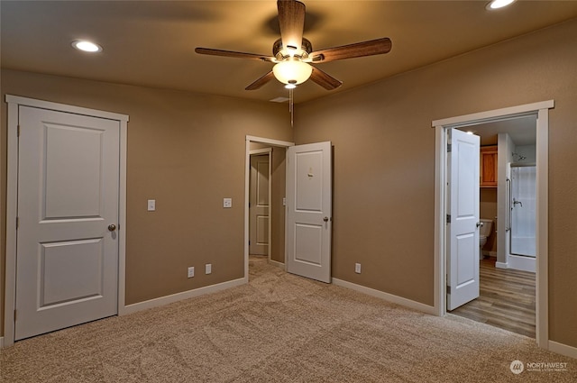 unfurnished bedroom with ceiling fan, ensuite bathroom, and light carpet