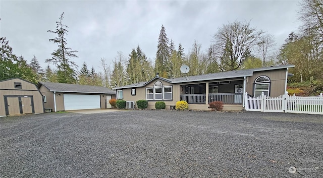 view of front of home featuring cooling unit, a storage shed, and a garage