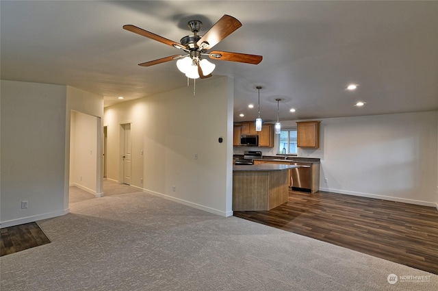 kitchen featuring appliances with stainless steel finishes, dark carpet, hanging light fixtures, and ceiling fan