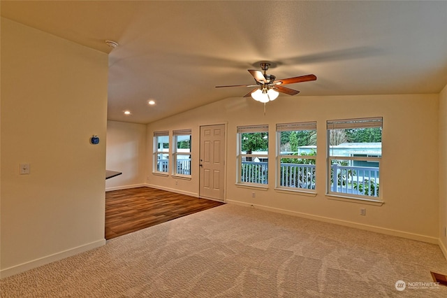 carpeted empty room with ceiling fan and lofted ceiling