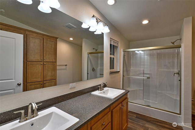 bathroom featuring vanity, hardwood / wood-style flooring, a shower with door, and lofted ceiling