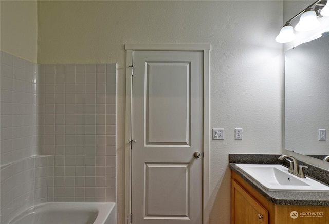 bathroom with a washtub and vanity