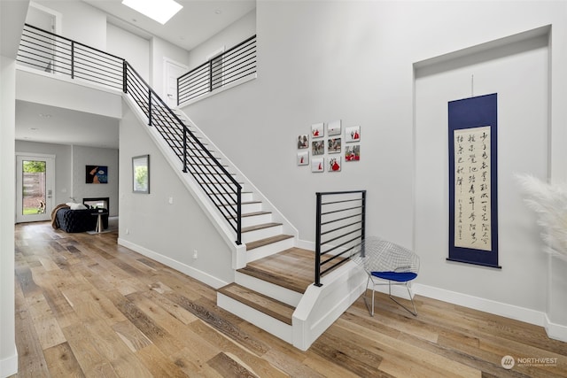 stairway featuring wood-type flooring and a high ceiling