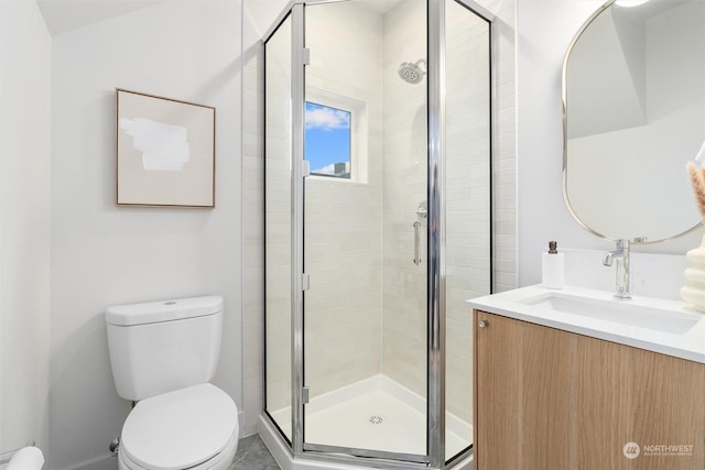 bathroom featuring tile patterned floors, vanity, toilet, and a shower with door