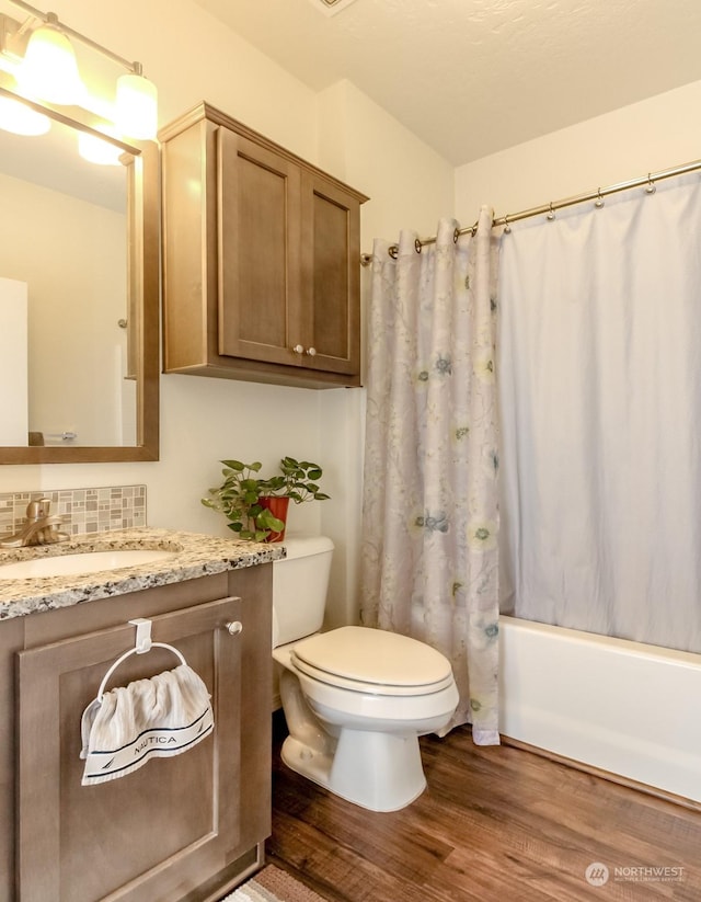 full bathroom with backsplash, vanity, hardwood / wood-style flooring, shower / bathtub combination with curtain, and toilet