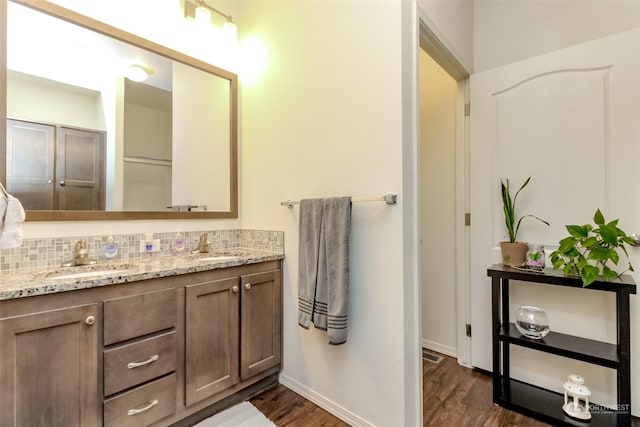 bathroom featuring hardwood / wood-style flooring, decorative backsplash, and vanity